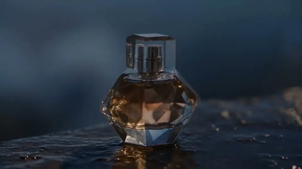 Cinematic slow dolly shot of a glass perfume bottle on wet black stone at blue hour, soft rim light, drifting mist, shallow depth of field, photorealistic product film